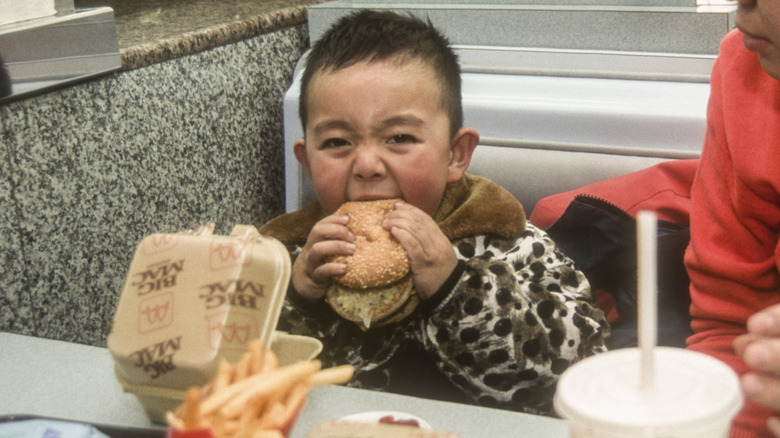 a child tries to eat a Big Mac