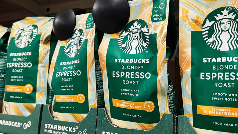 Bags of Starbucks blonde roast espresso beans sit on a grocery store shelf.
