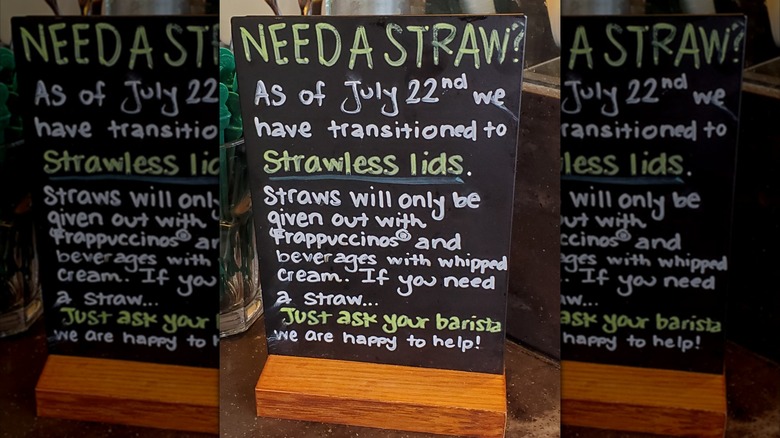 Handwritten sign indicates the Starbucks locations has switched to strawless lids.
