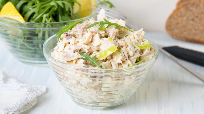 Chicken salad bowl beside arugula bowl