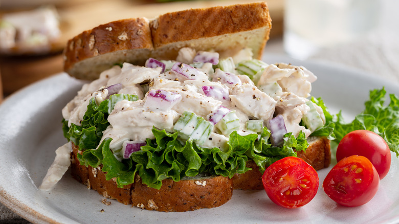 chicken salad sandwich beside cherry tomatoes