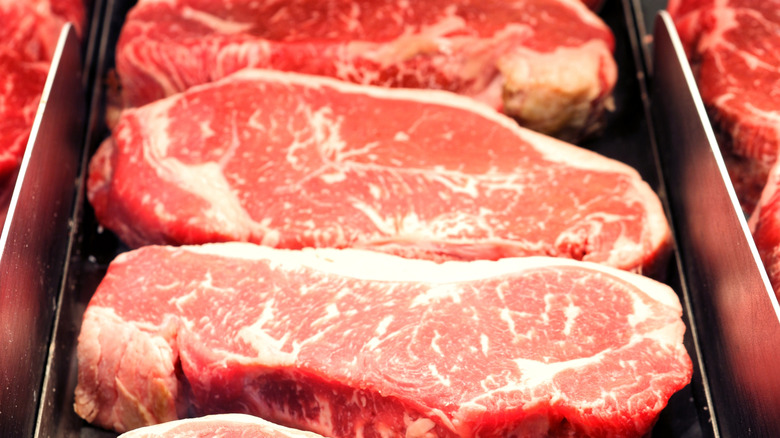 Line of raw steaks in cooler