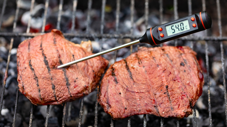 Meat thermometer in steak on a grill
