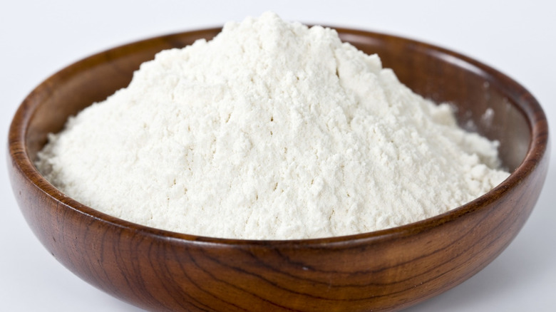 Mound of flour in wooden bowl