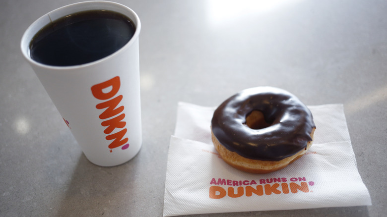 Dunkin coffee next to chocolate donut
