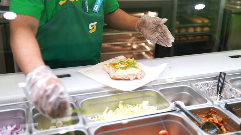 Subway sandwich artist making sub