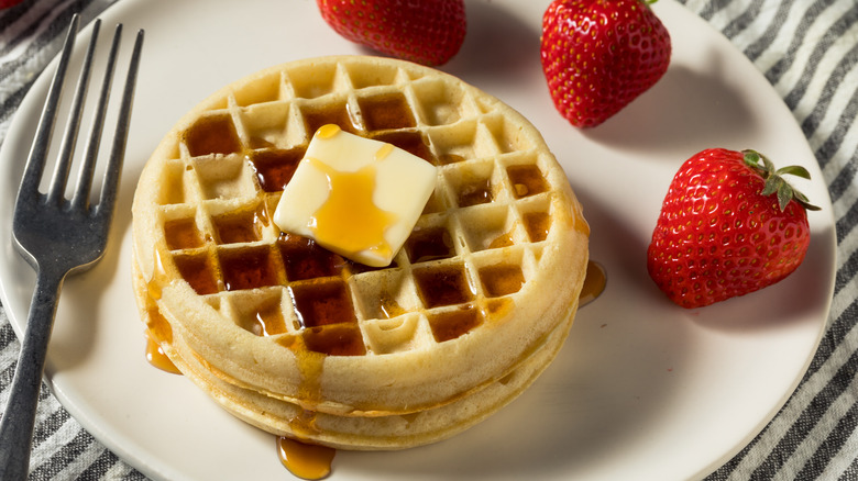 Breakfast waffles with syrup and strawberries