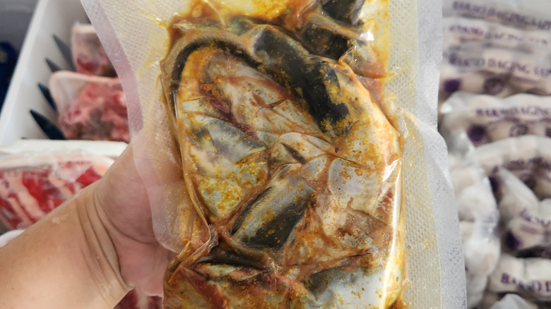 A pack of frozen sheatfish with spices