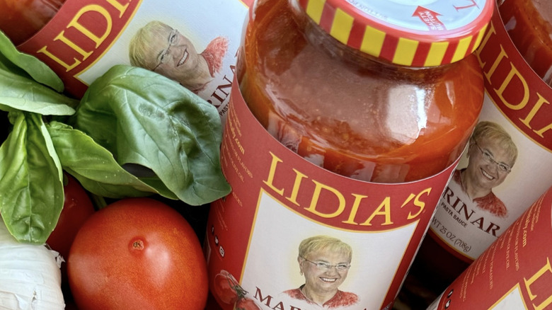 Jars of Lidia's marinara sauce with fresh produce