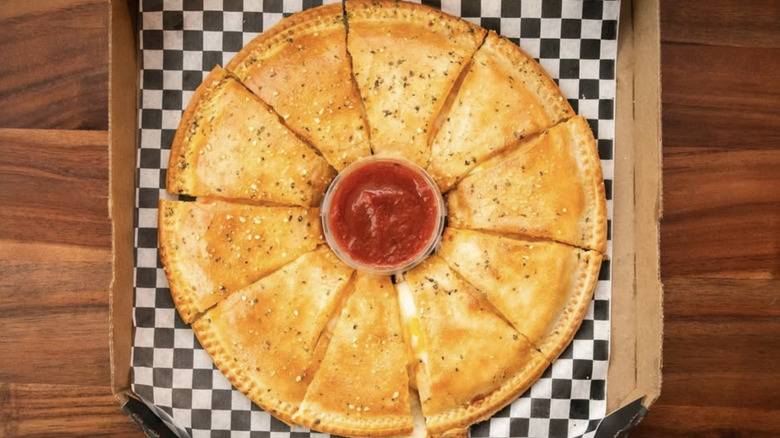Italian cheesy bread with marinara sauce in cardboard box