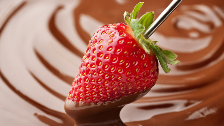 Dipping a strawberry in chocolate