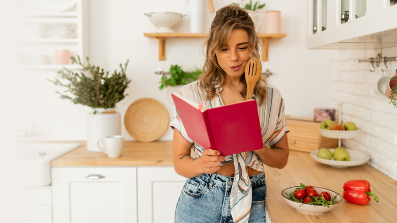 woman looking at cookbook
