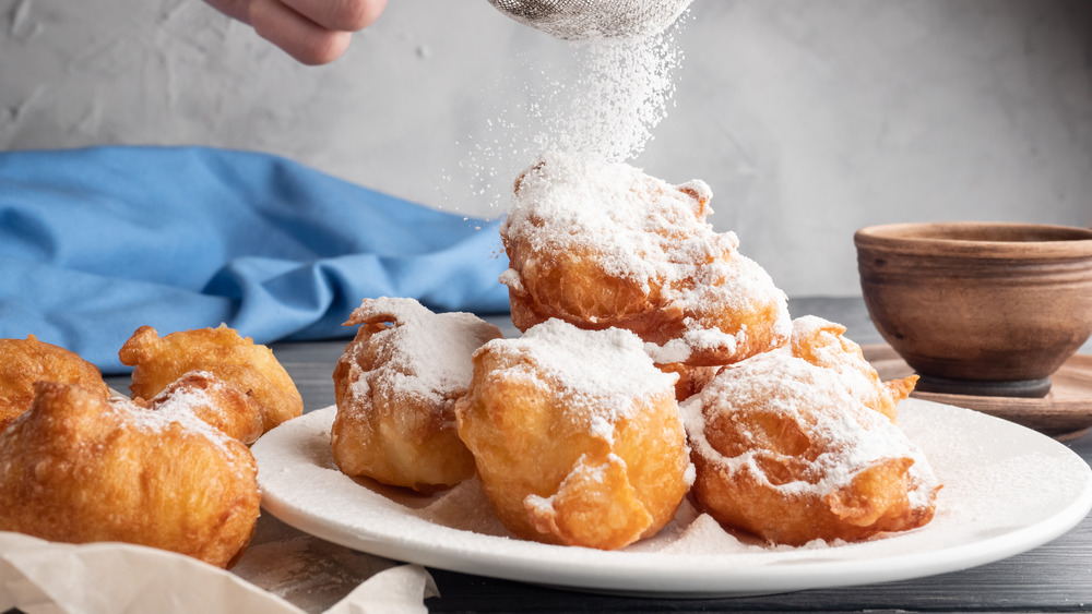 Powdering beignets