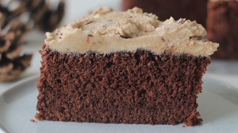 slice of chocolate cake with frosting on white plate