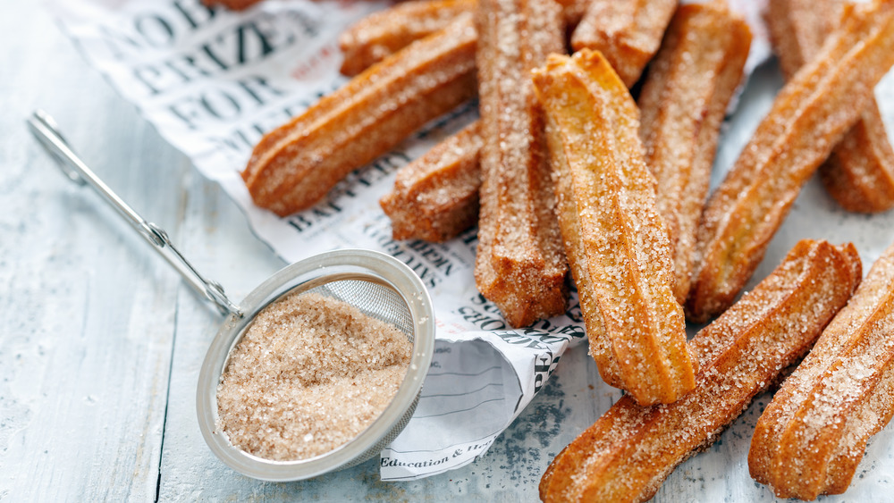 Churros with cinnamon and sugar in a sieve