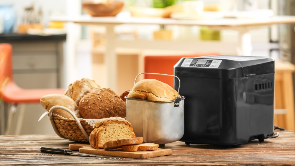 bread machine next to loaves of bread