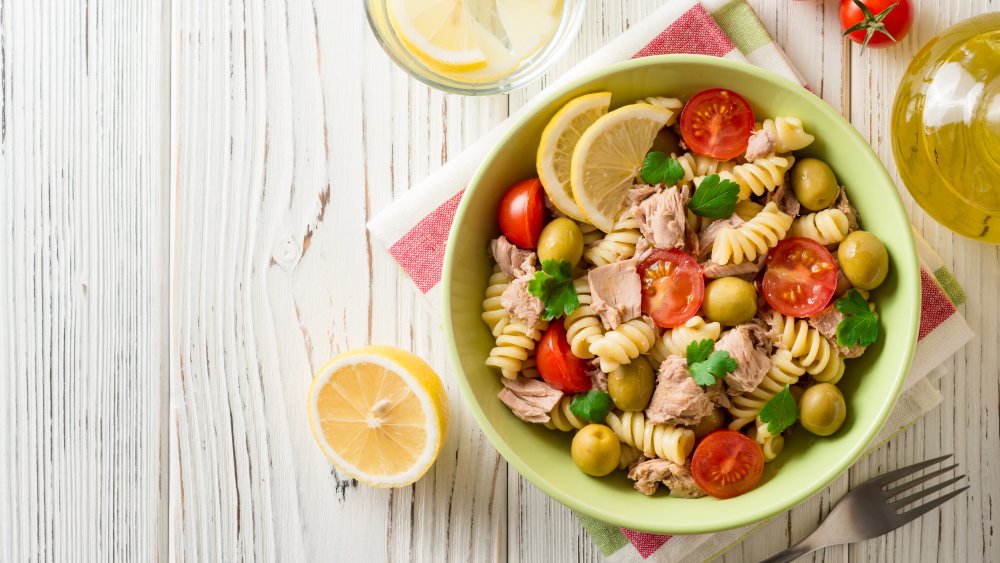 A bowl of good pasta salad with tuna, tomatoes, and lemon.