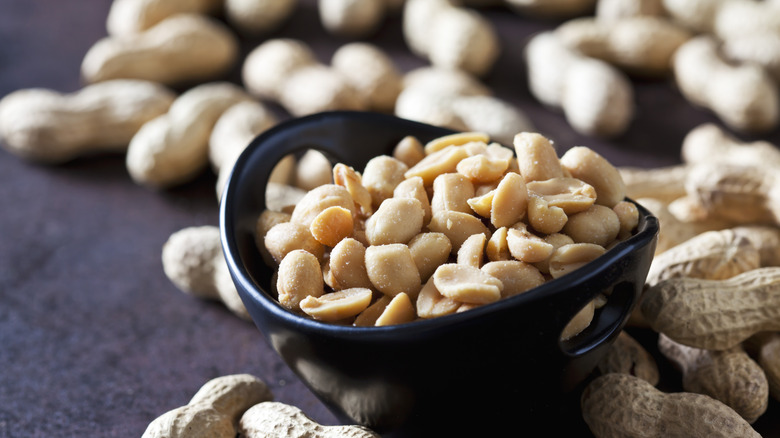 Salted peanuts in a bowl surrounded by shells