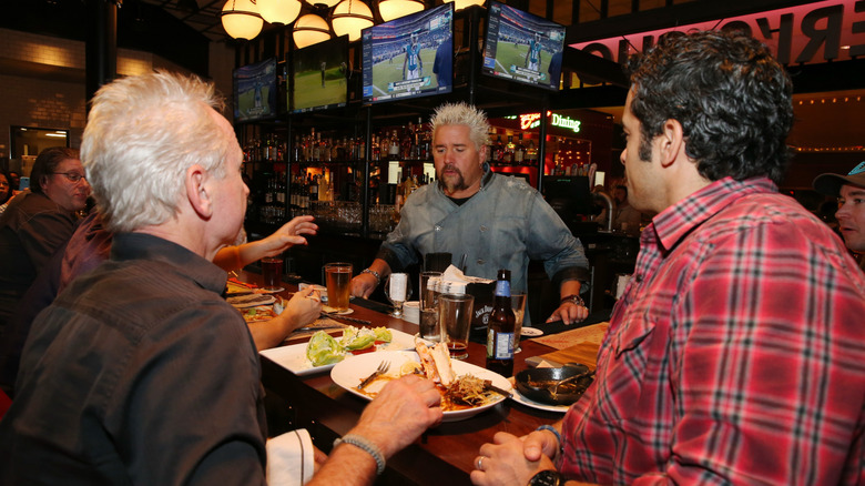 Guy Fieri interacts with customers at the bar of his Chophouse restaurant