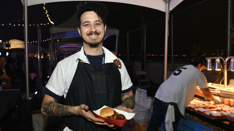 Adam Harvey posing for photo cooking outside at night