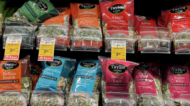 Several varieties of Taylor Farms bagged salads on display in grocery store.