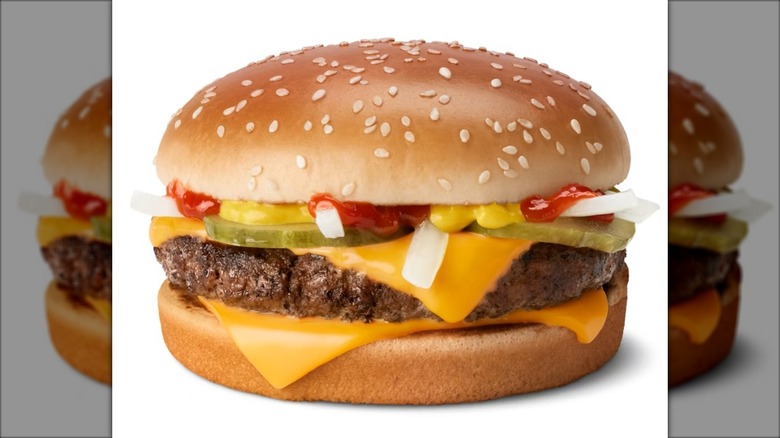 A Quarter Pounder burger from McDonald's with slivered onions and other toppings.