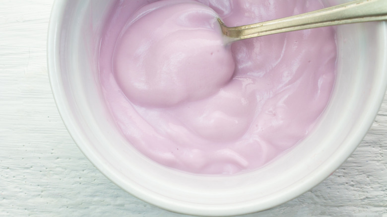 Pink yogurt in white dish with spoon
