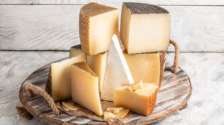 Wedges of cheese stacked on a board