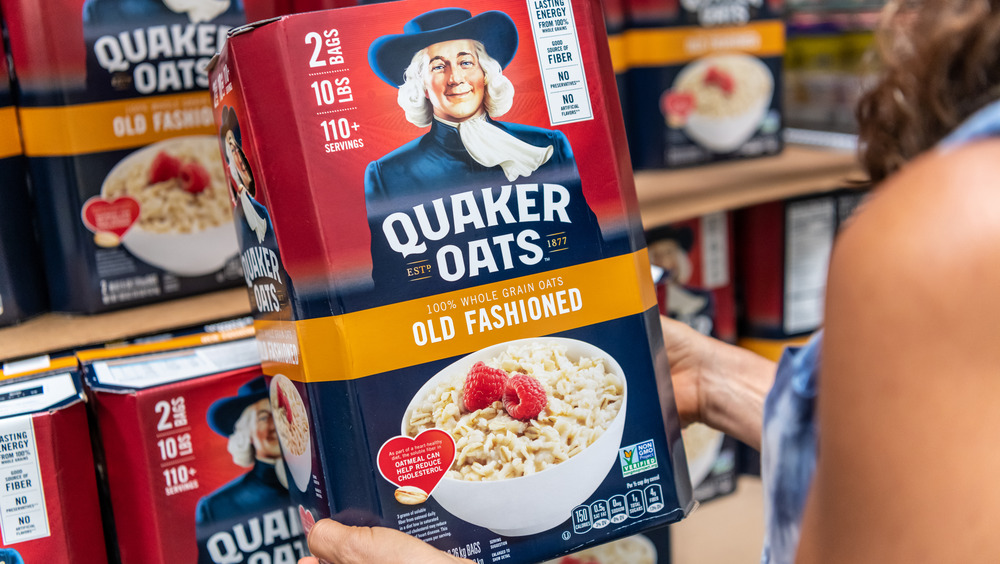 Person holding Quaker Oats box