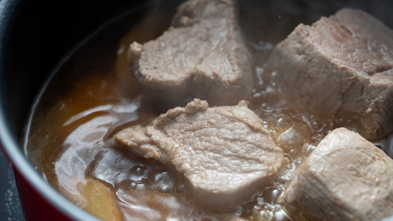 Ribs boiling in pot on stove.