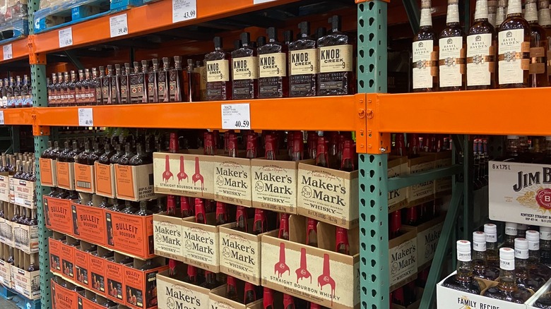 Assorted whiskey and bourbon bottles on Costco shelf.