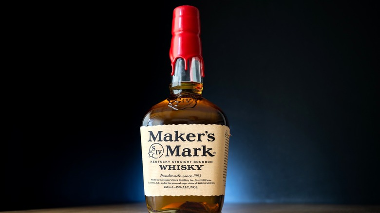 A sealed bottle of Maker's Mark bourbon against a dark backdrop.
