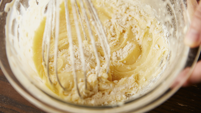 baking batter being whisked in a glass bowl