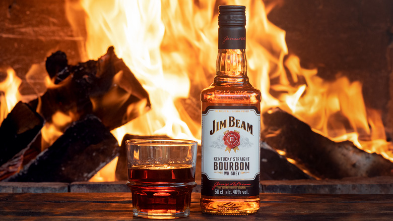 Jim Beam bottle by a fire