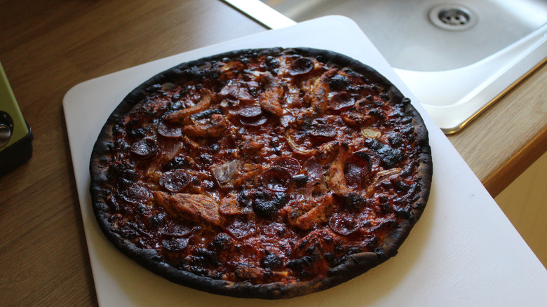 Burnt pizza on a serving board