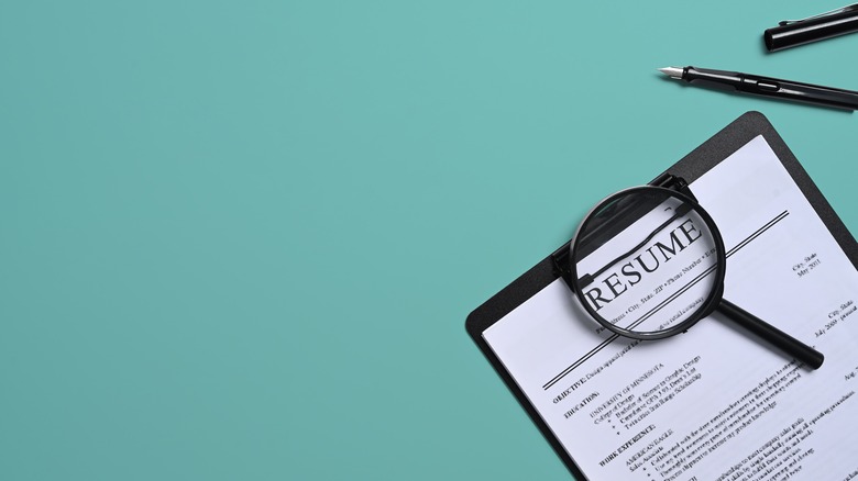 A resume being examined by a magnifying glass