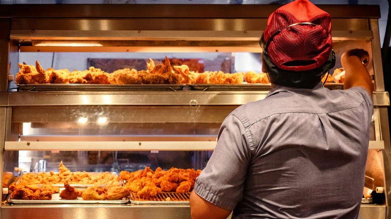 Worker handling fried chicken