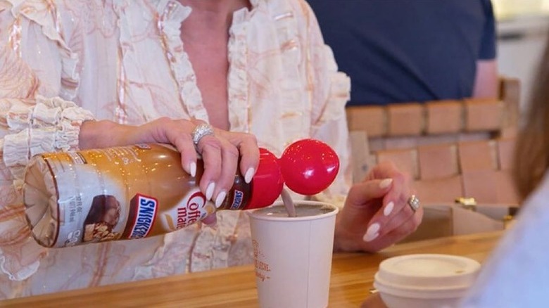 Margaret Josephs pours Coffee Mate Snickers-flavored creamer into her coffee