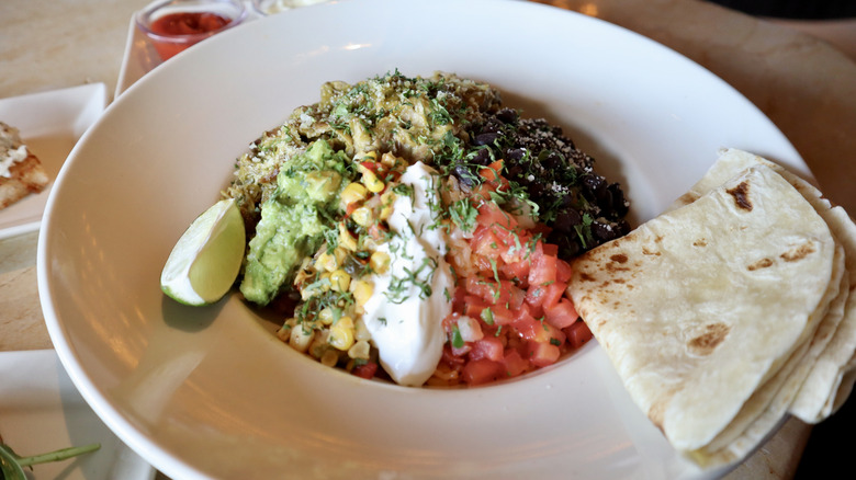 colorful carnitas bowl with tortilla on the side