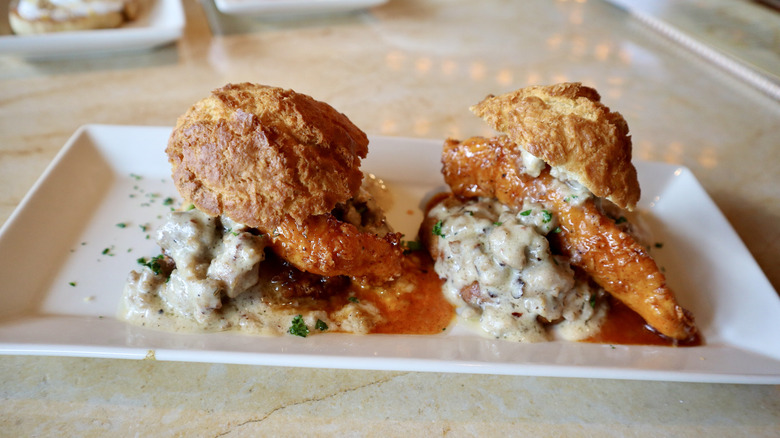 Biscuts with chicken and gravy on white plate