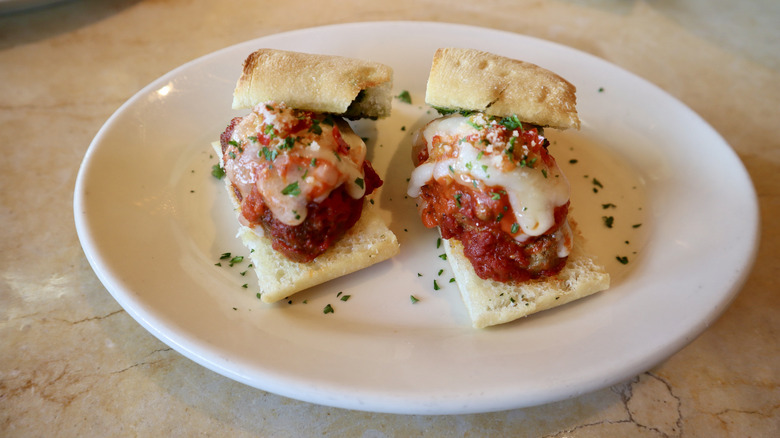 Two small meatball sliders on white plate