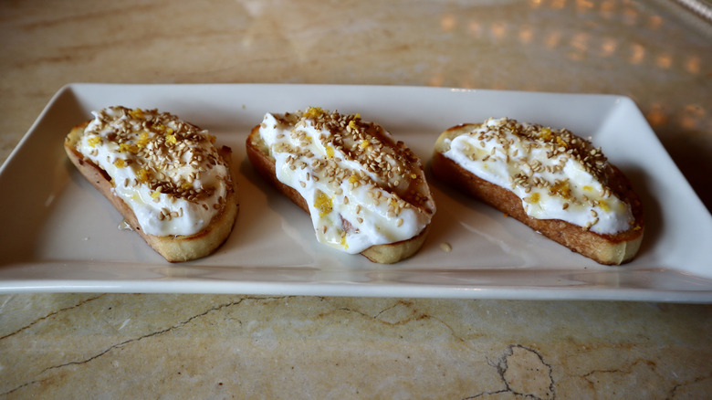 Three slices of ricotta topped bread on plate