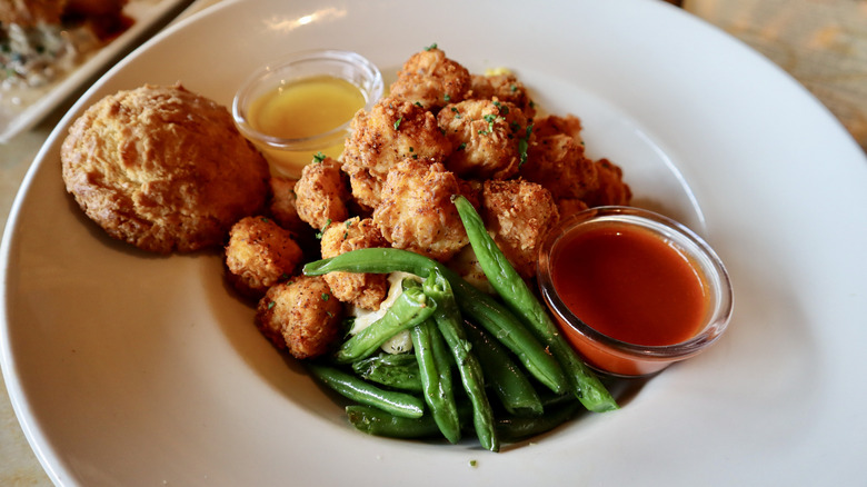 Chicken green beans biscuit and sauce in white bowl
