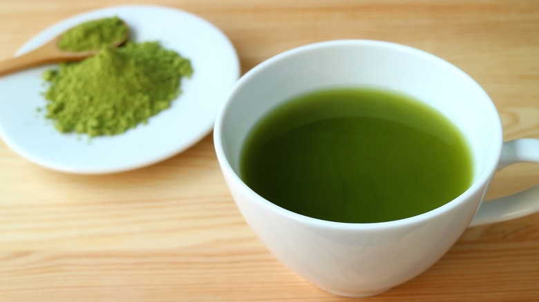 Cup of matcha tea and powder