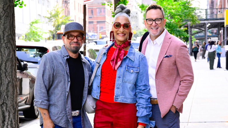 Michael Symon, Carla Hall, and Clinton Kelly pose for a photo outdoors