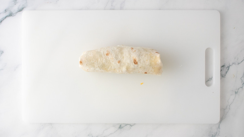 Rolled up wrap on cutting board