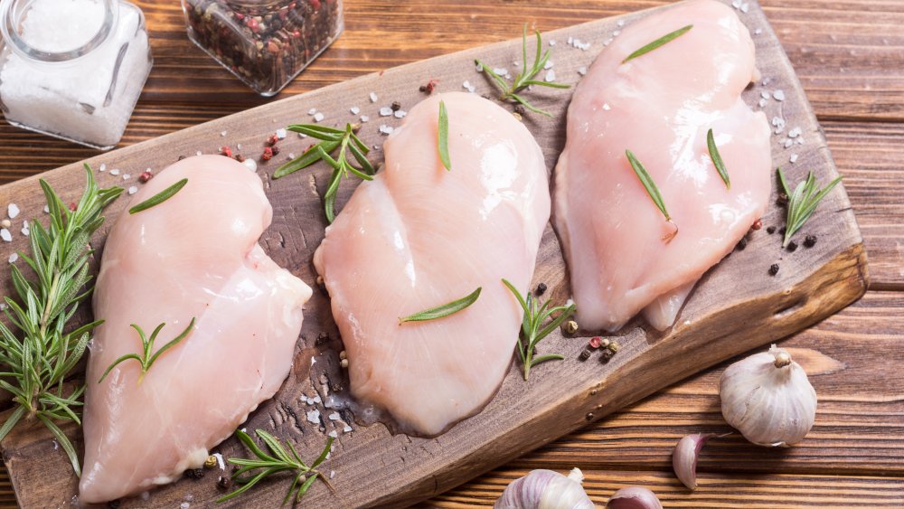 three chicken breasts on a cutting board
