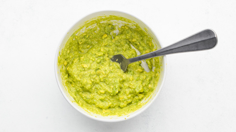 Guacamole in white bowl with fork