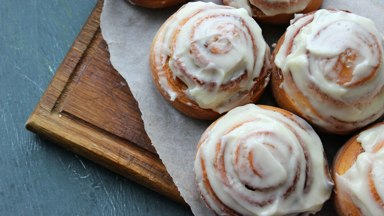 Iced cinnamon rolls on a cutting board
