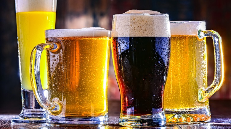 Four glasses holding different types of beer.